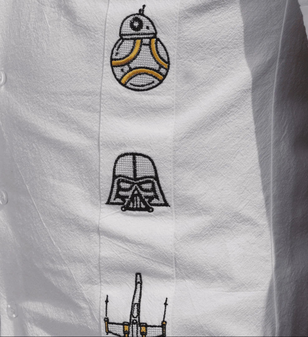 Modelo masculino posando con guayabera blanca de manga larga en lino y algodón de Guayaberas LeMaan, con bordados artesanales inspirados en el equilibrio de una galaxia lejana.