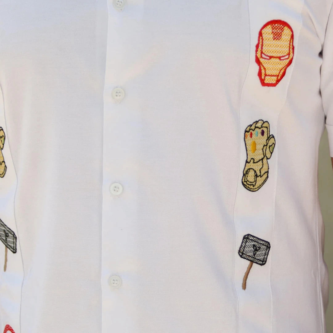 Modelo masculino posando con una guayabera blanca de manga larga en lino y algodón, destacando bordados de símbolos de unión y fuerza inspirados en un universo de héroes legendarios, de Guayaberas LeMaan.